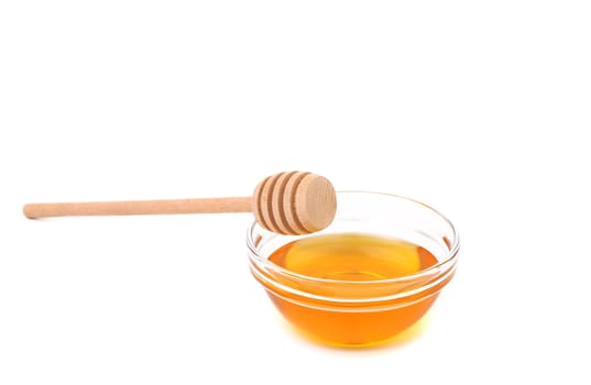 Wooden spoon on bowl with honey. White background.