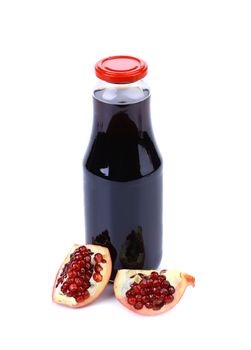 Bottle of juice and ripe piece grenade on white background
