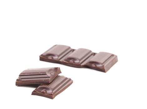 Tasty morsel of dark chocolate. White background.