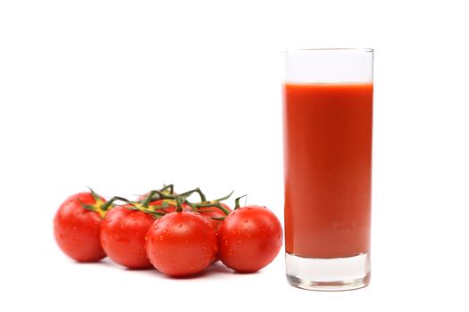 glass of juice and tomatoes on a white background