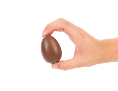 Hand holds chocolate egg. Isolated on a white background.