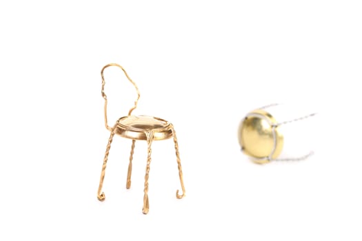 Golden muzzle and chair made out of it. White background.