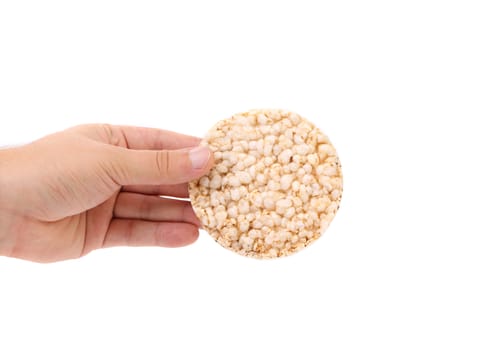 Hand holds a rice cake. White background.