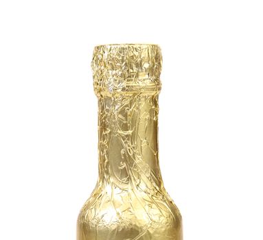 Bottle neck wrapped with gold foil. White background.