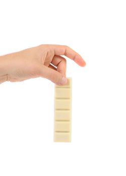 Hand holds white chocolate bar with filling. White background.