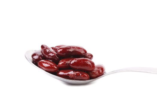 Kidney bean in metal spoon, isolated on white background