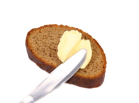 Buttering knife on brown bread. White background.