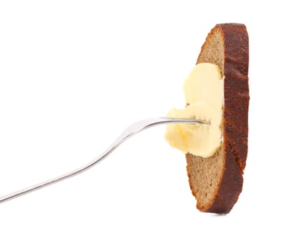 Brown bread and butter on a fork. White background.