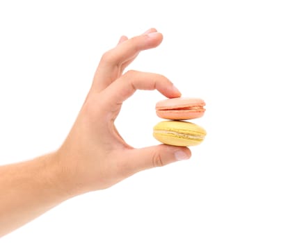 Hand holds macarons. Isolated on a white background.
