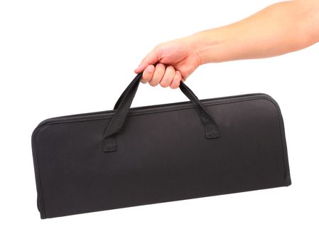 Hand holds black set of skewers for barbecue. White background.
