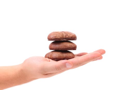 Hand holds chocolate meringues. Close up. White background.