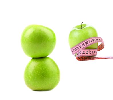 Green apples with tape measure. White background.