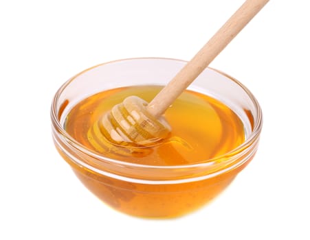 Glass bowl of honey with wooden drizzler isolated on white background