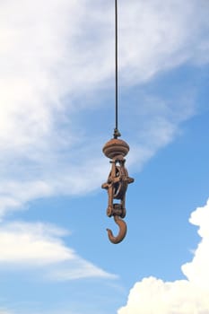 Old crane hook against a blue sky