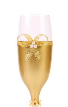 Decorated wedding golden glass wuth bow. White background.