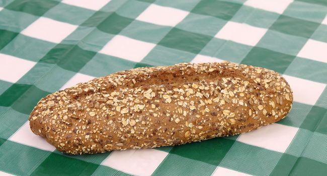 Multi - grain bread on a check tablecloth. Close up.