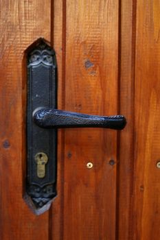 locking handle on the front wooden door. Close up.