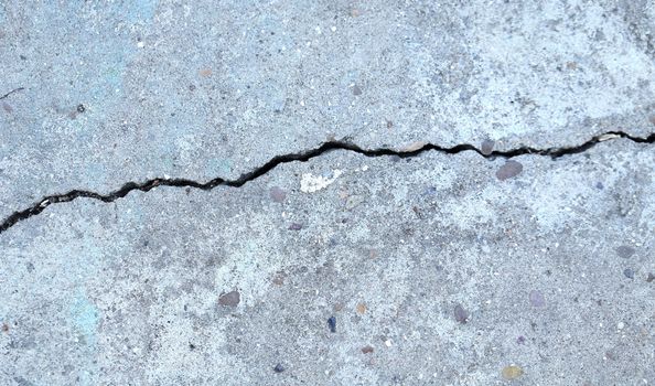 Fissure on the gray concrete wall. Cloth up.
