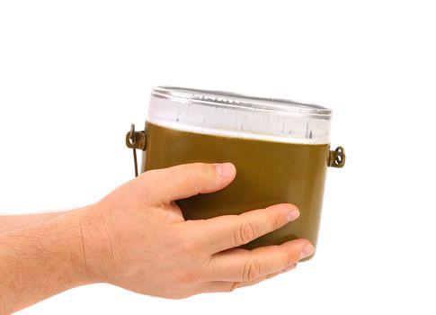 Hands holds green aluminum military mess-tin. White background.