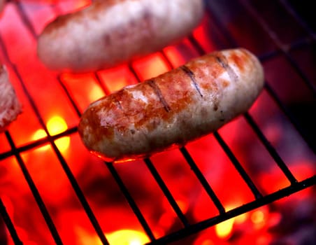 Juicy grilled sausages on a flaming grill. Close up.