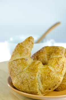 close up  croissants on  brown dish  and a white  cup of coffee with spoon , fresh food