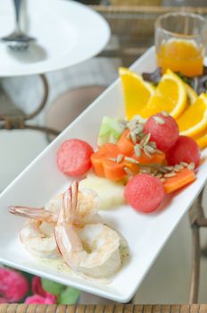summer salad with boiled shrimp and mixed fruits served with  orange sauce on dish