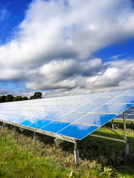 Solar Panel on a green meadow with blue sky and white clouds