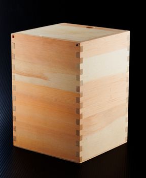 A wooden box over a black background