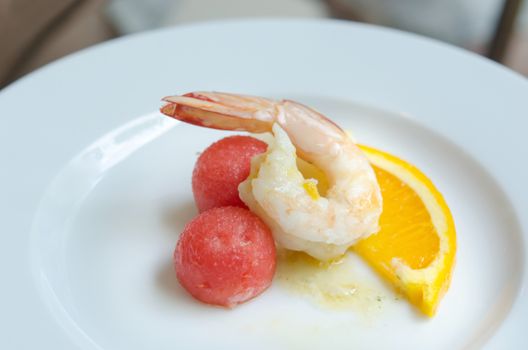  boiled shrimp , watermelon and slice orange with sauce on dish