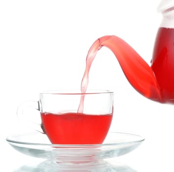 Tea being poured into glass tea cup isolated on a white background