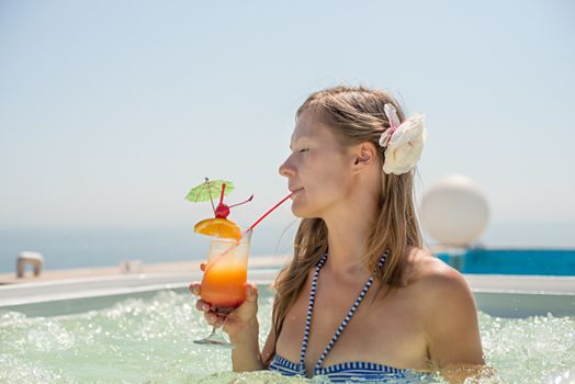 Woman drinking tropical cocktail at  beach resort