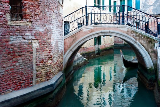 Gandola under the bridge on a small Venice street