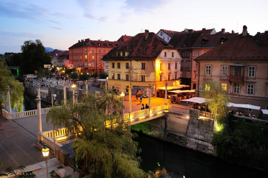 Ljubljana, Slovenia - September 4, 2013: People walking at old town embankment in Ljubljana. This year the city of Ljubljana is competing for the title of European Green Capital 2016.