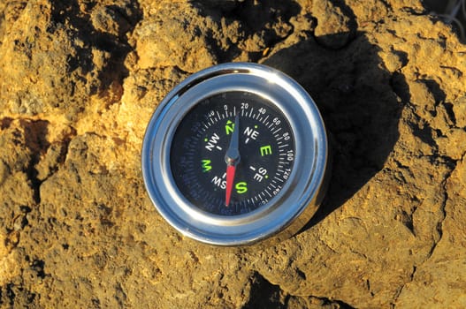 Orientation Concept Metal Compass on a Rock in the Desert