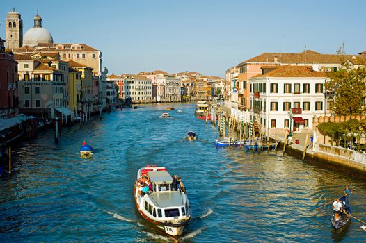 Venice, Italy - September 5, 2013: People touring the famous Venice Canals on boats  in Venice. Currently the city is testing new movable flood barriers.