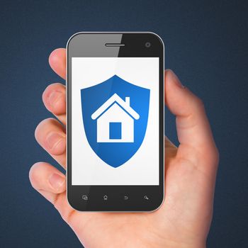 Safety concept: hand holding smartphone with Shield on display. Mobile smart phone in hand on Blue background, 3d render