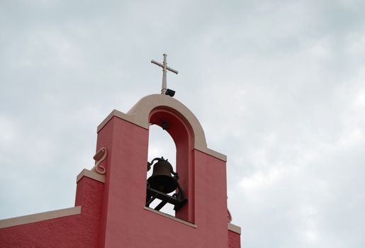 cross and bell on church steeple