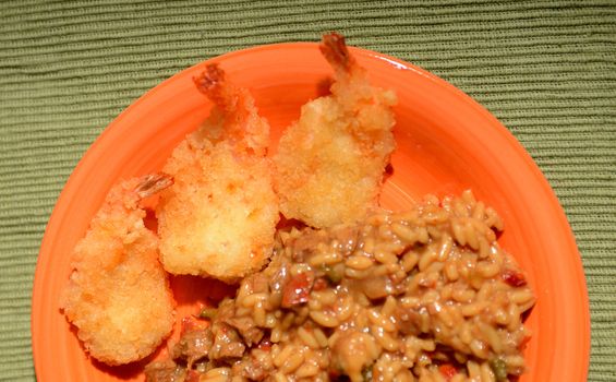 fried shrimp and jambalaya on orange plate