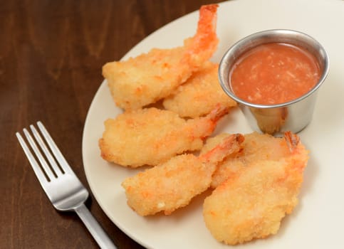 fried shrimp and hot sauce on wood background