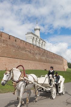 White old horse carriage is popular attraction for tourists in Novgorod.