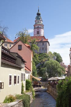 CESKY KRUMLOV, CZECH REPUBLIC AUGUST 21, 2012:Narrow Canal and The Castle Tower. The tourists visit the national treasure Cesky Krumlov saved by UNESCO since 1992.