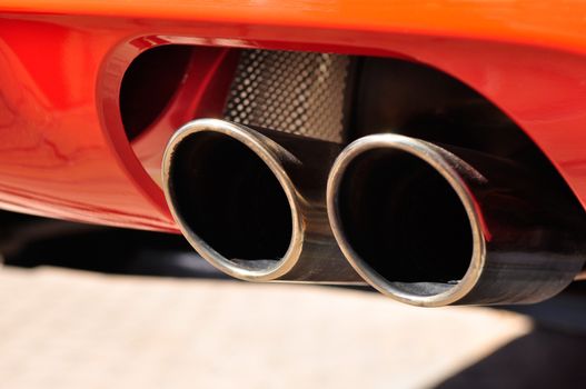 Close up of a red car dual exhaust pipe