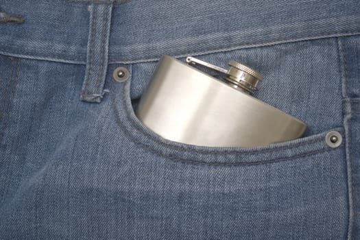 Silver hip flask in a denim jeans pocket