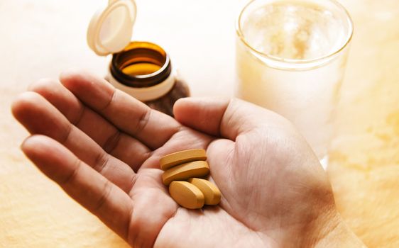 Hand holding yellow pills