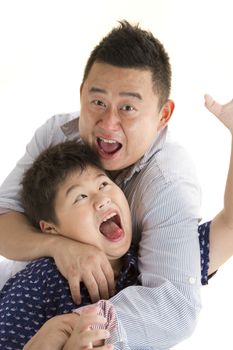 Asian Father and son playing wrestling with isolated white backrgound 
