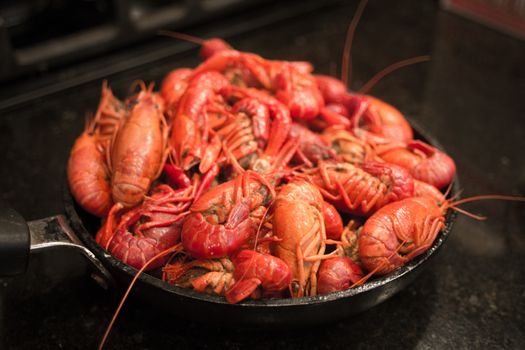 A beautiful red skillet full of crawfish, freshly steamed and ready to eat.