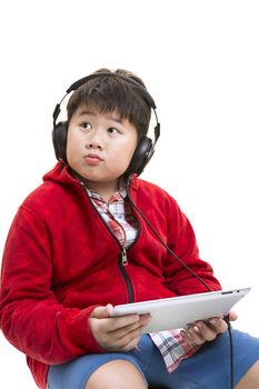 Vertical shot of a young Asian boy in red listening to music with a headphone isolated on white.