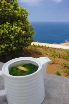 A pot of fresh leaves tea, made of peppermint leaves and lemon peel.