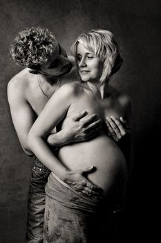 Loving happy couple, pregnant woman with her husband, black and white, looking at each other