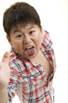 A young Asian boy jump forward to scare the camera.